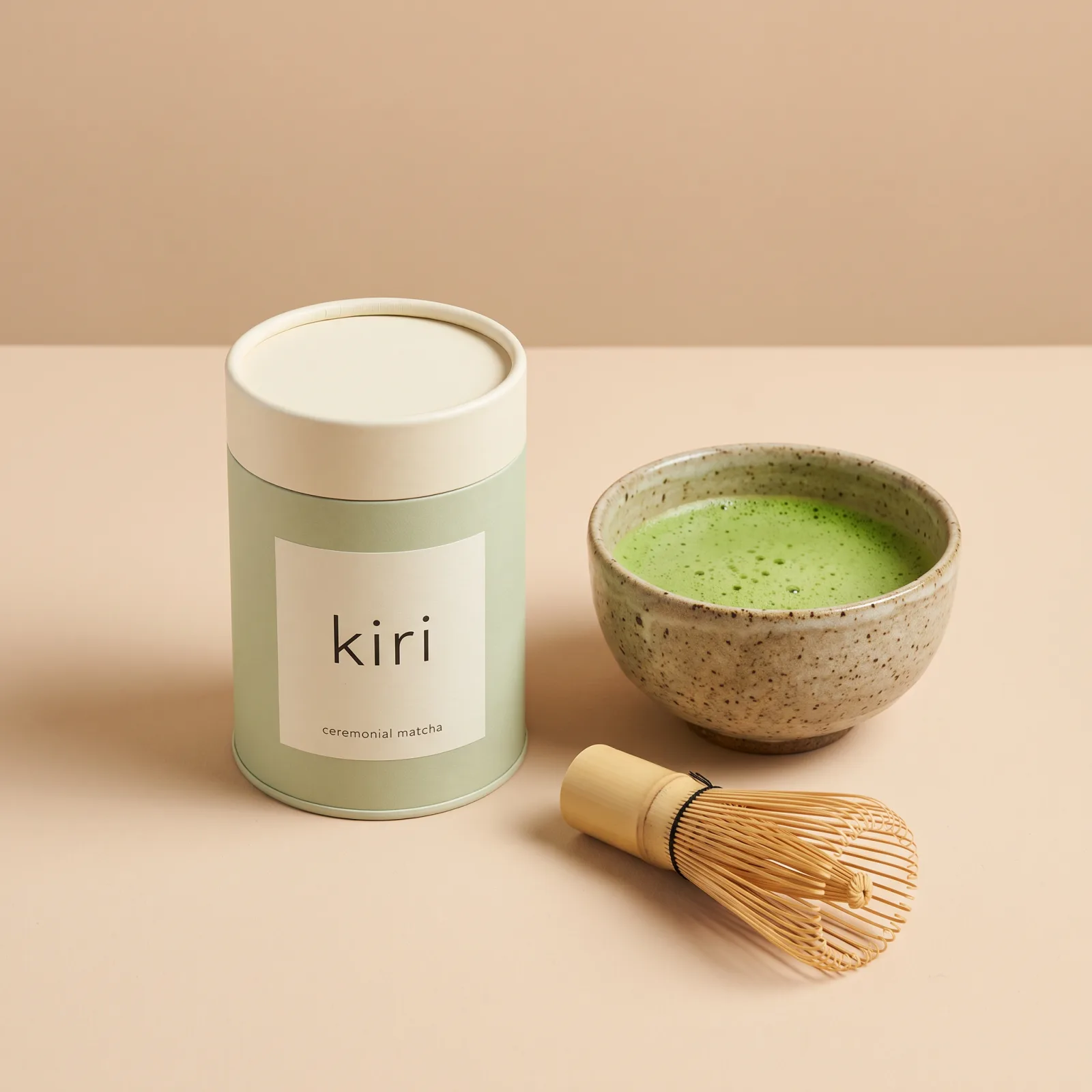 The kiri tin: a matte pale-green tin with a cream lid and a kiri label, next to a bamboo whisk and a bowl of matcha