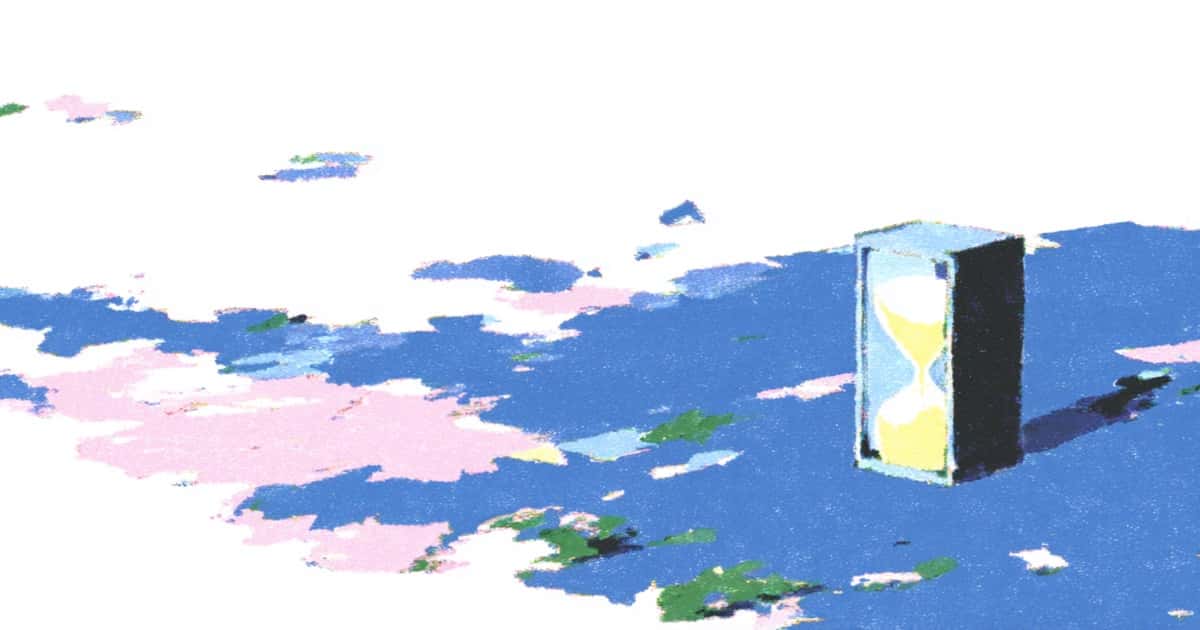 曇り空の下、平らな面に立つ砂時計
